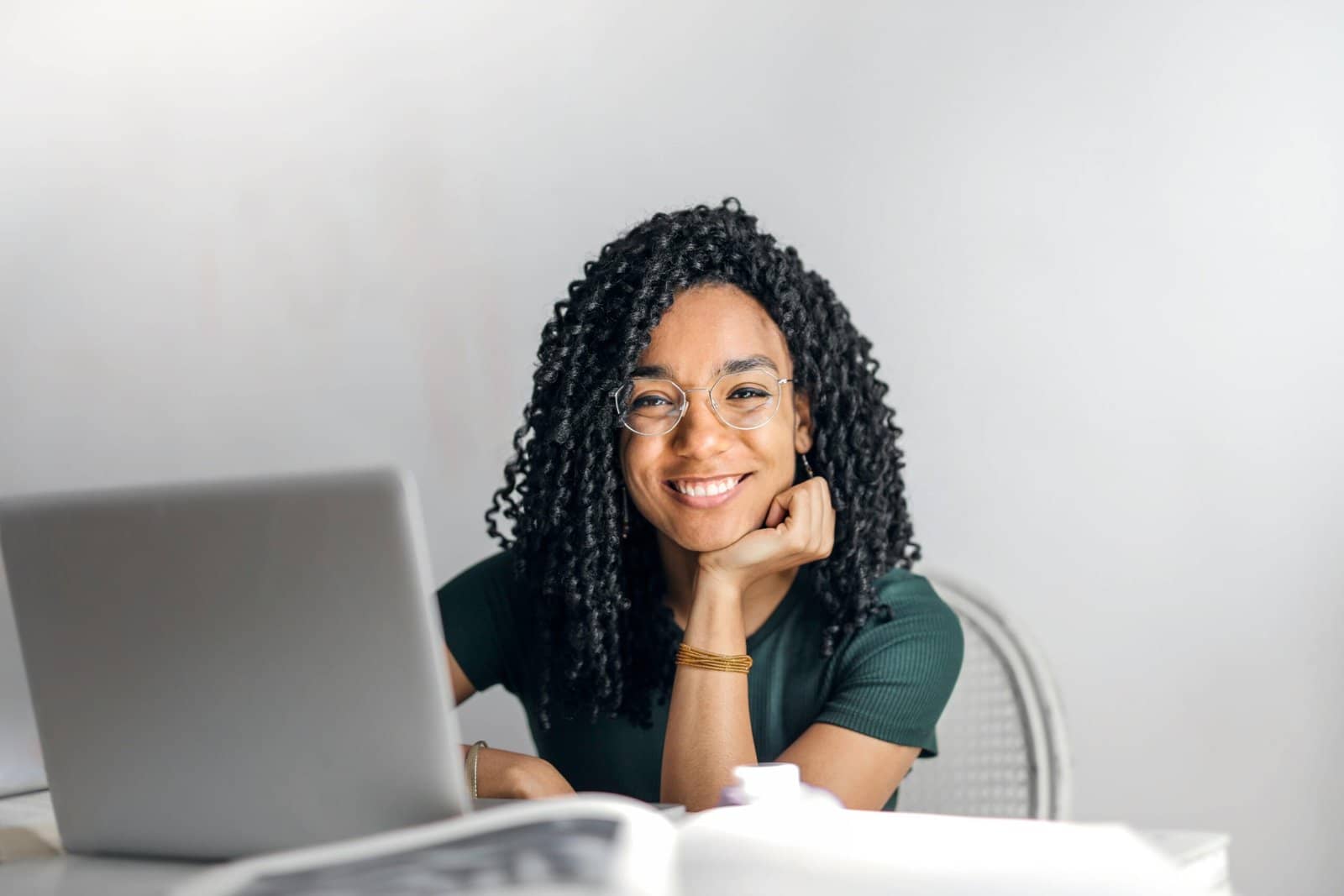 An online therapist sitting at her computer and smiling at her client