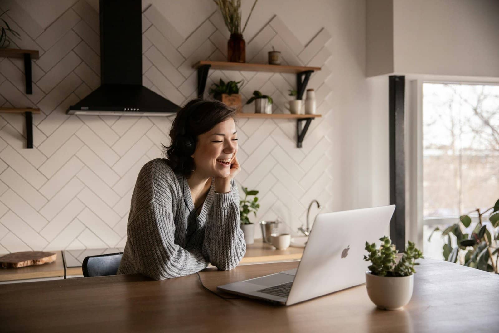 A therapist providing free online therapy from the comfort of her own home and smiling at her computer