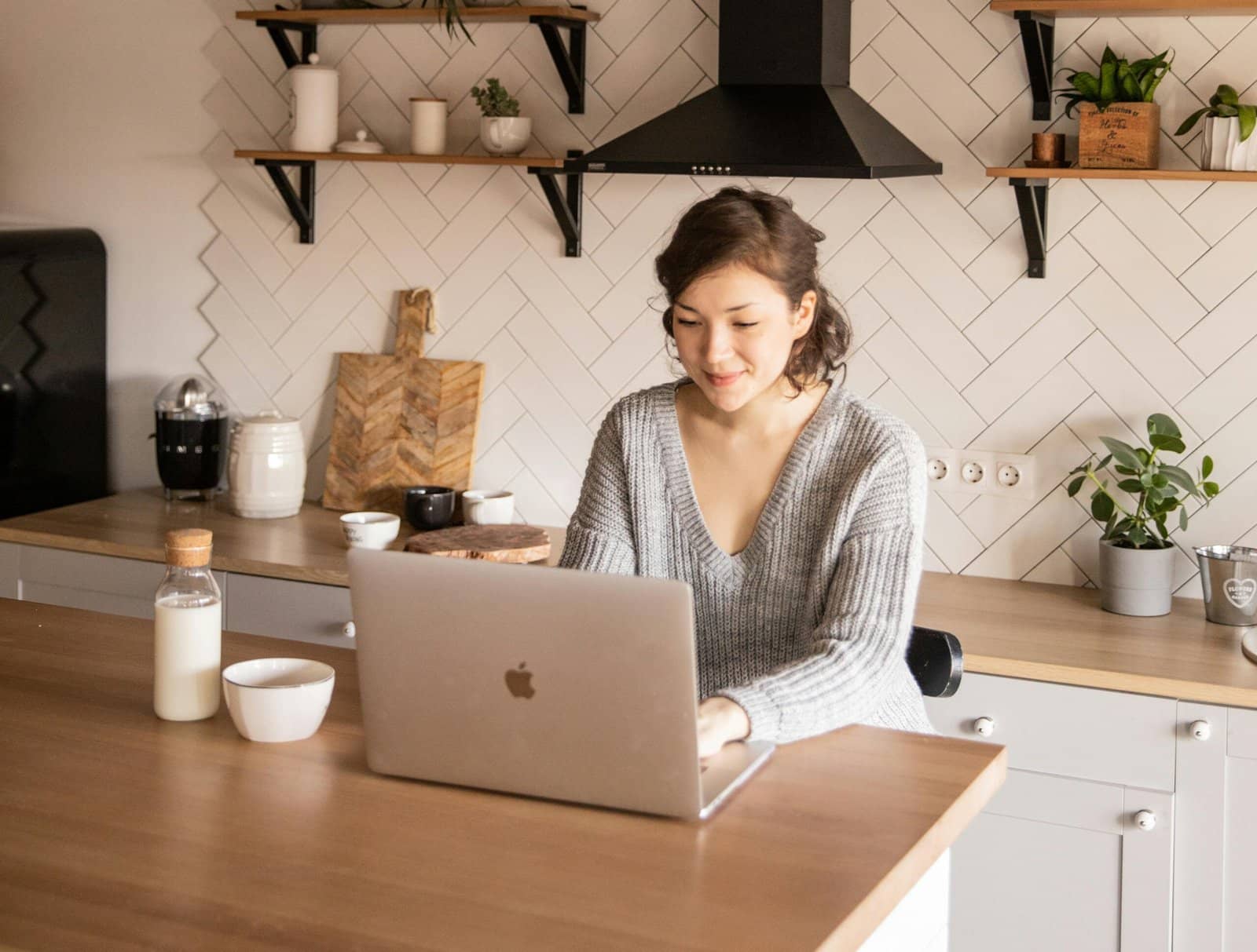 A woman sitting at her desk using her silver laptop to search for therapists in Toronto